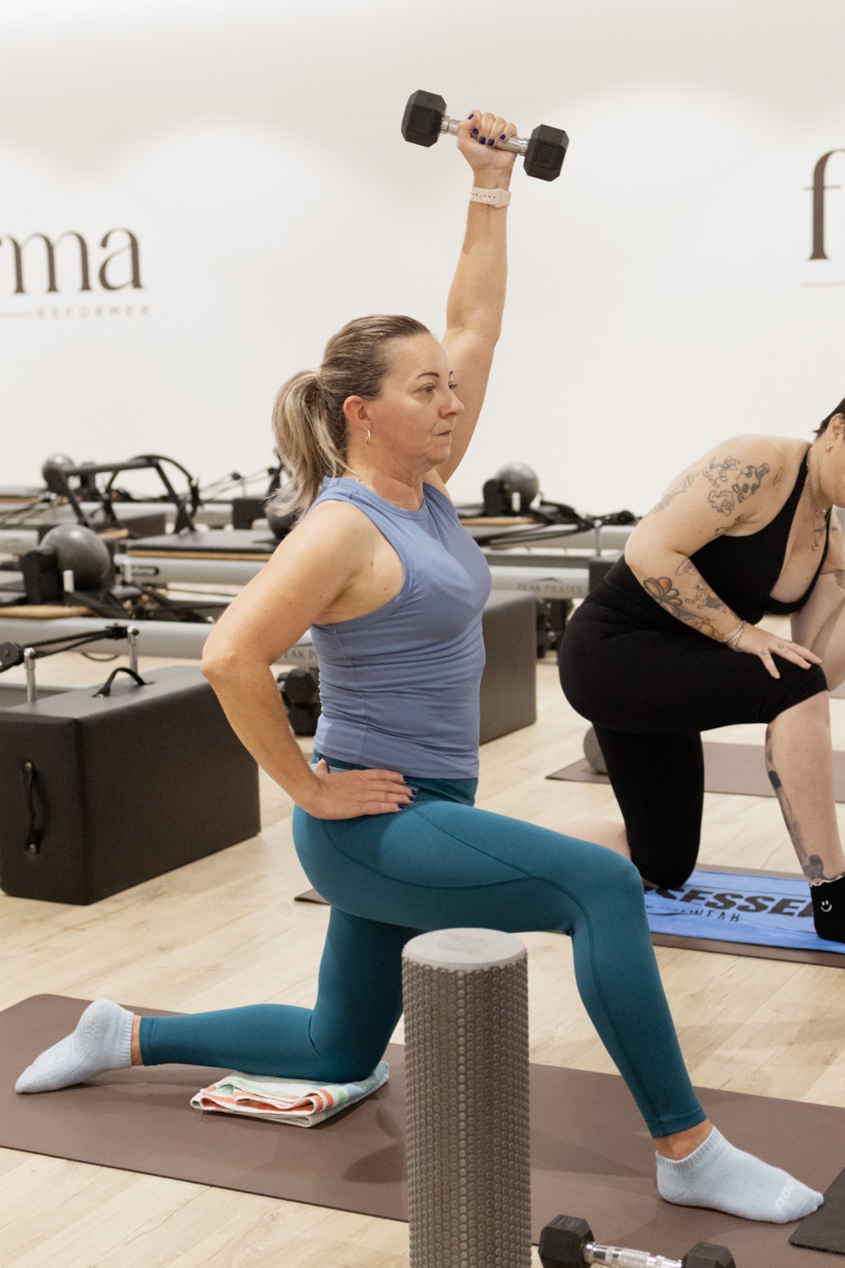 A Forma participant exercising with a dumbbell